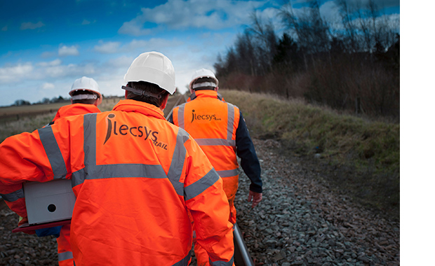 Men in hi-vis and helmets walking along track